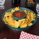 A table with a bowl of salsa and chips served in HS Inc. Jalapeno deli servers.
