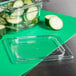 A clear plastic Cambro lid with cucumber slices in it.