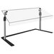 A clear table with a black base and white rectangular object with black trim underneath a clear acrylic sneeze guard.