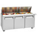 A Turbo Air 3 door refrigerated sandwich prep table with food in it.