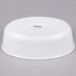 A white porcelain oval deep dish platter with white text on a white background.