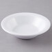 A white Carlisle Kingline melamine fruit bowl on a gray surface.