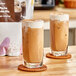 Two glasses of iced mocha on a wooden table.