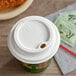 A white EcoChoice compostable hot cup lid on a coffee cup.
