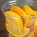 A clear Bare by Solo deli container filled with orange slices on a counter.