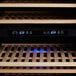 A close up of an AvaValley wine cooler with blue lights on a wooden slat.