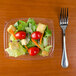 A salad in a Dart clear rectangular plastic container with a fork.