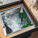 An Astella outdoor mobile bar with bottles and ice in a cooler.