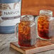 Two glass jars with ice and Narvon Old Fashioned Cola on a wooden surface.
