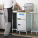 A man standing in a kitchen using an Anets natural gas fryer.