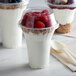 A close-up of three yogurt parfaits in Dome PET lids with raspberries and yogurt.