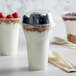 A group of yogurt cups with blueberries and granola topped with a Dome PET Lid.