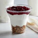 A dessert in a 9 oz. PET plastic cup with yogurt, granola, and cranberry sauce.