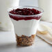 A 9 oz. PET parfait cup filled with yogurt topped with granola and cranberry sauce.