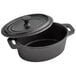 A black cast iron oval Dutch oven with a lid.