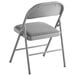 A Lancaster Table & Seating grey folding chair with a padded seat.