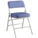 A blue Lancaster Table & Seating folding chair with a white frame.