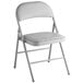 A white folding chair with a gray cushioned seat.