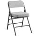 A Lancaster Table & Seating gray fabric folding chair with a 2" padded seat and black frame.