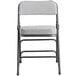 A Lancaster Table & Seating grey fabric folding chair with a 2" padded seat and black metal frame.