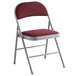A Lancaster Table & Seating burgundy fabric folding chair with a metal frame and padded seat.