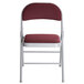 A Lancaster Table & Seating burgundy fabric folding chair with a padded seat.