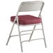 A Lancaster Table & Seating folding chair with a burgundy cushion.