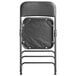 A black Lancaster Table & Seating folding chair with a black padded seat.