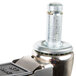 A close up of a MetroMax iQ swivel stem caster with a silver metal knob.