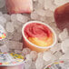 A Whole Fruit cup with pink and yellow frozen mixed berry and lemon swirl desserts.