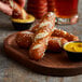A plate of J & J Bavarian Bakery Mini Soft Pretzel Sticks with mustard for dipping.