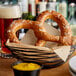 A basket of SuperPretzels next to a glass of beer on a table.