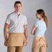A man and woman wearing Choice khaki standard waist aprons with 3 pockets.