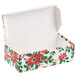 A white candy box with red and green poinsettias on it and an open lid.