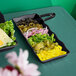 A black GET Osslo rectangular melamine tray with a variety of food on it.