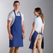 A man and woman wearing Choice royal blue aprons with white background.