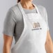 A woman wearing a white Choice bib apron with the word "cook" in black.