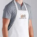 A man wearing a white Choice bib apron with the word "Cobb" on it.