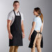 A man and woman standing next to each other in black Choice aprons.