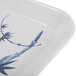 A white melamine tray with a blue bamboo design on a table.