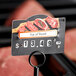 A Choice Butcher deli tag wheel with a price tag on meat.