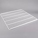 A white coated wire shelf with a grid.