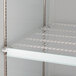 A white coated wire shelf for an Avantco refrigerator.