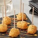 A black plate with appetizers on Royal Paper Eco-Friendly Wood Skewers.