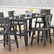 A Lancaster Table & Seating wooden trestle table base in a restaurant dining area with chairs and wine glasses.