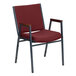 A red Flash Furniture Hercules stack chair with armrests.