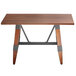 A Lancaster Table & Seating wooden table with live edge and metal trestle legs.