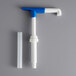 A blue and white plastic Torani beverage pump with a white plastic pipe and nozzle.