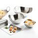 A group of Libbey brushed metal bowls filled with food.