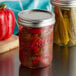 Two Ball 16 oz. wide mouth glass canning jars filled with pickled red and yellow peppers.